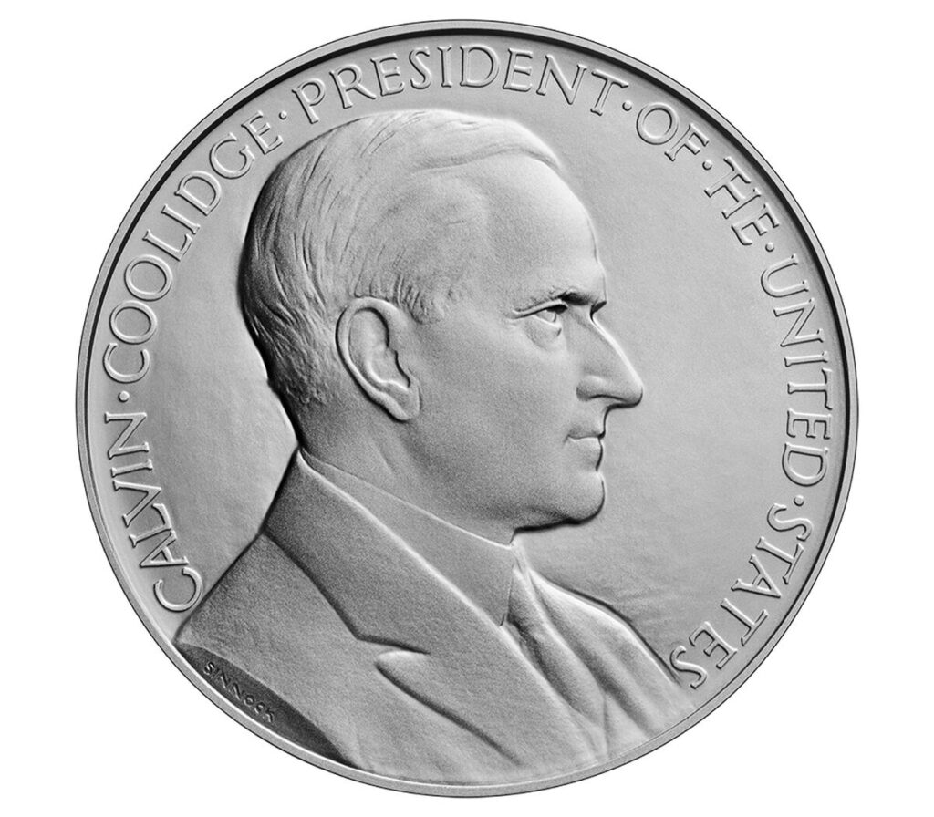 Reverse of the Calvin Coolidge Presidential Silver Medal showing a seated figure holding fasces, a heraldic eagle and a cornucopia inside a laurel wreath