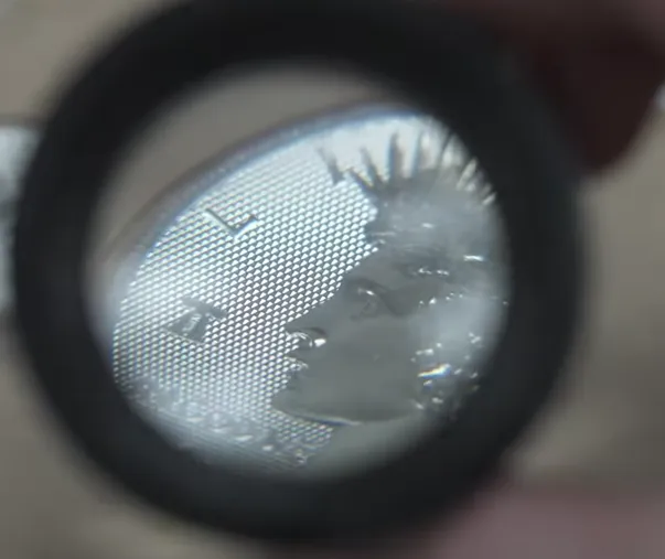 Close up of the 2026 Diamond Field Peace dollar obverse showing the faceted diamond pattern field and the smooth Liberty Bell 250 privy mark beside Liberty's profile