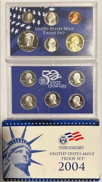 Complete sealed 2004 U.S. Mint proof set showing both plastic lenses, including the five state quarters, above the printed Statue of Liberty outer box